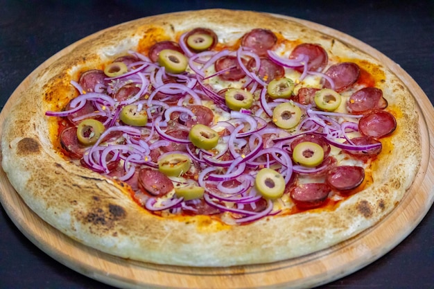 Pizza traditionnelle brésilienne au pepperoni dans un objectif sélectif Pizza Calabresa