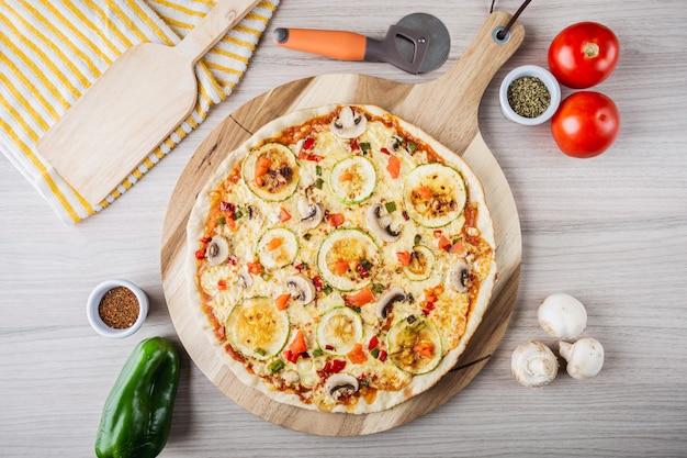 Pizza végétalienne aux courgettes avec champignons, tomates, poivrons et origan