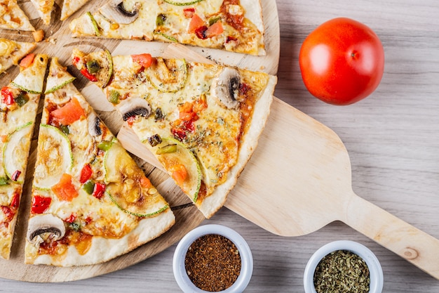 Photo pizza végétalienne à la courgette avec tomate, origan et merken