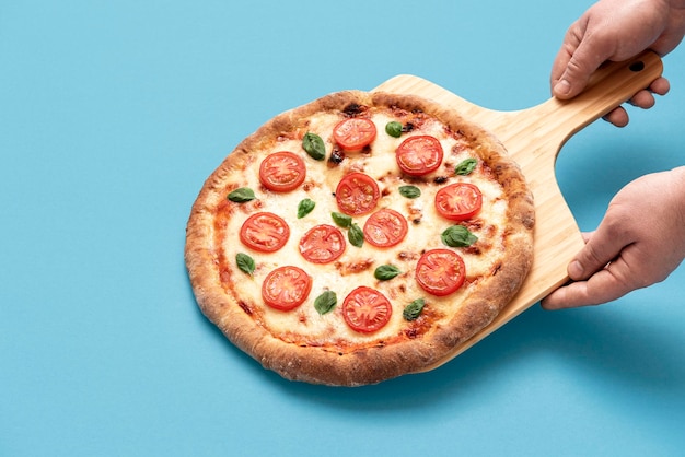 Pizza végétarienne aux tranches de tomate Pizza fraîchement cuite sur une planche de bois