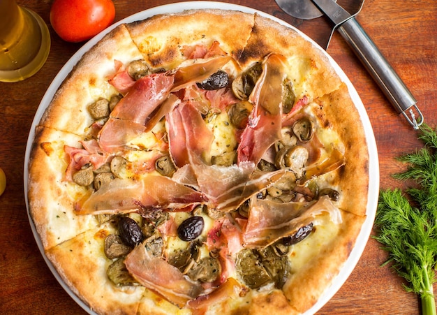 Photo pizza à la viande assortie avec jamon et olives