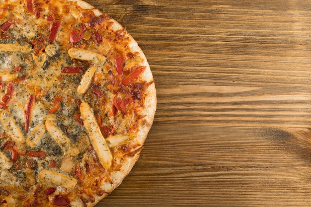 Pizza à la viande entière sur fond de bois