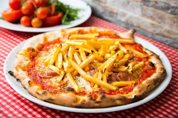 Pizza à la viande avec frites. Pizza napolitaine avec sauce tomate et viande. Recette italienne authentique.