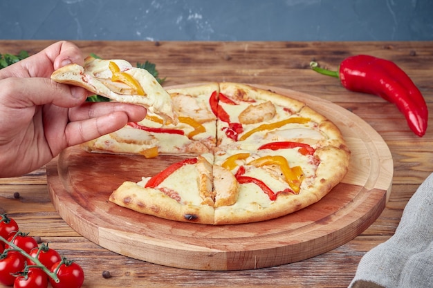 Pizza à la viande, légumes et champignons, fond en bois