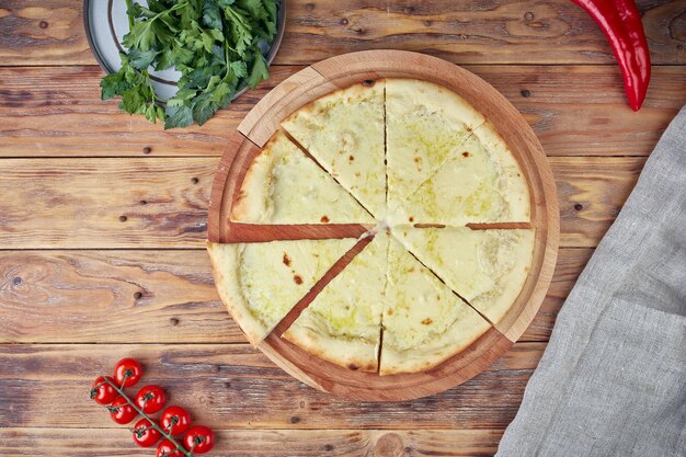 Pizza à la viande, légumes et champignons, fond en bois