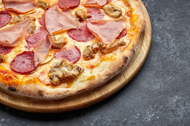 Pizza à la viande, saucisse, viande et champignons sur fond gris avec place pour le texte. Pizza 4 viande