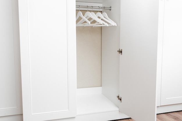 Photo placard armoire vide blanc avec cintres cintres blancs en bois sur une tringle annonce de vente de magasin