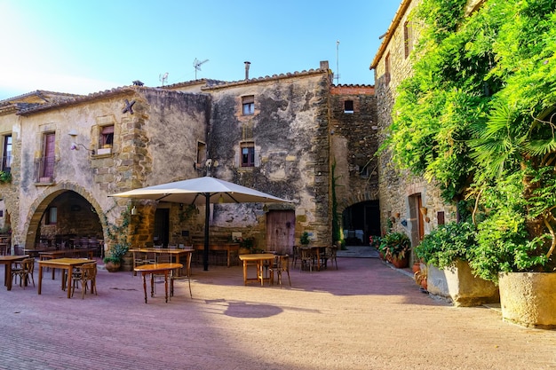 Place centrale du magnifique village médiéval de Monells avec ses maisons en pierre et ses vignes vertes Gérone Catalogne