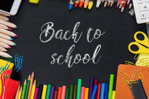 placé avec des lettres de retour à l'école et un ensemble d'équipements scolaires sur le tableau noir