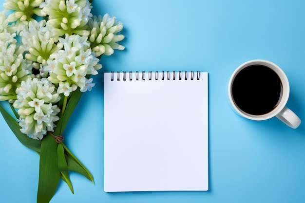 Placé à plat avec une fleur de jacinth avec une tasse de café et un cahier ouvert à l'arrière-plan rustique