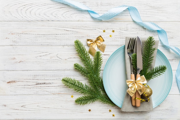 Place de table de Noël avec décor de Noël et assiettes, kine, fourchette et cuillère. Fond de vacances de Noël. Vue de dessus avec espace de copie