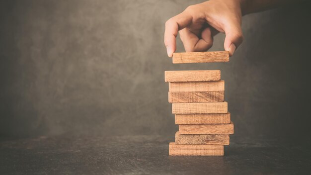 Placer un bloc de bois à la main empilé