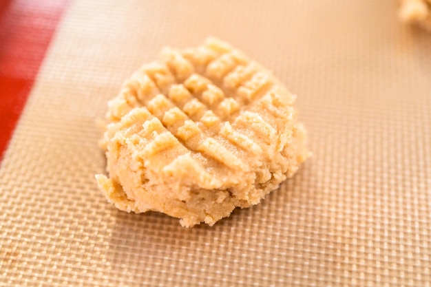 Placer une pâte à biscuits au beurre de cacahuète sur des tapis en silicone pour la cuisson.