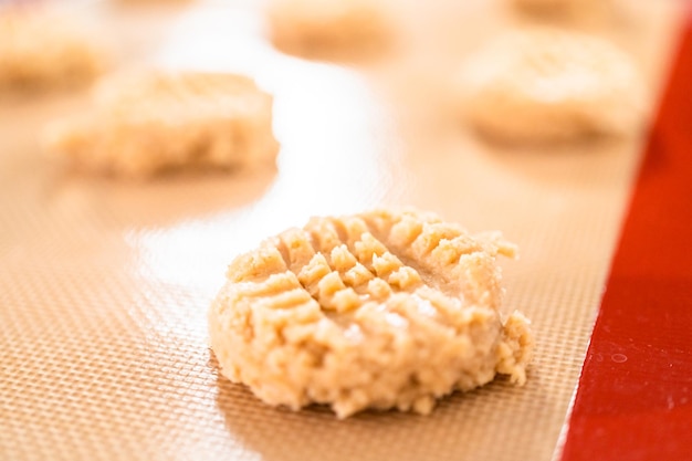 Placer une pâte à biscuits au beurre de cacahuète sur des tapis en silicone pour la cuisson.