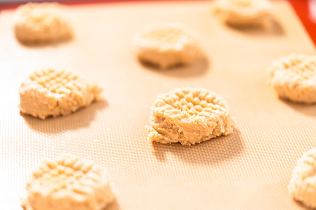 Placer une pâte à biscuits au beurre de cacahuète sur des tapis en silicone pour la cuisson.