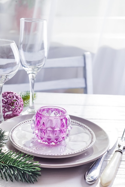 Placez la table pour table blanche de Noël avec des éléments de décor violet avec des branches vertes arbre de Noël