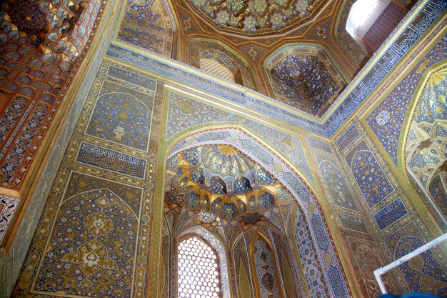 Plafond décoré d'or et de mosaïques à l'intérieur du Sherdor Madrasah, l'Oulougbek sur la place du Registan à Samarkand. 29.04.2019