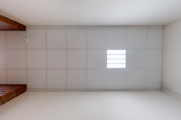 Plafond étiré ou suspendu à cassette avec des lampes à taches halogènes carrées et une construction en mur de plâtre dans une pièce vide de la maison ou du bureau
