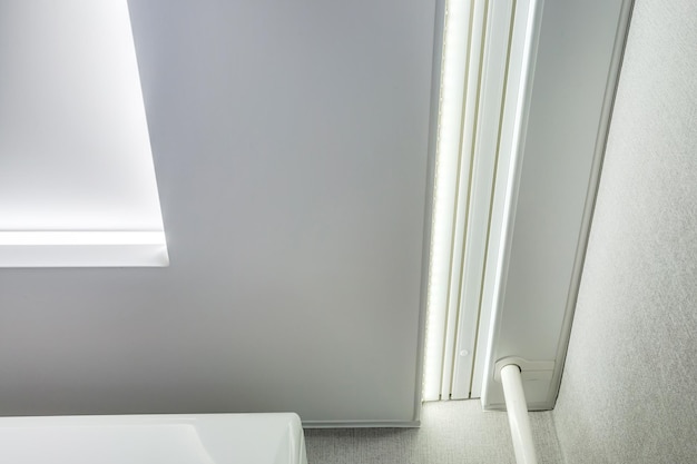 Plafond suspendu avec lampes halogènes et construction de cloisons sèches dans une pièce vide d'un appartement ou d'une maison Plafond tendu blanc et de forme complexe