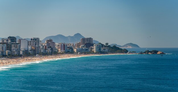 Photo la plage animée d'ipanema au coucher du soleil avec un point de vue bondé