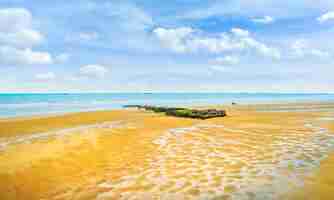 Photo la plage d'arromanches les bains et les vestiges du port artificiel en normandie, france