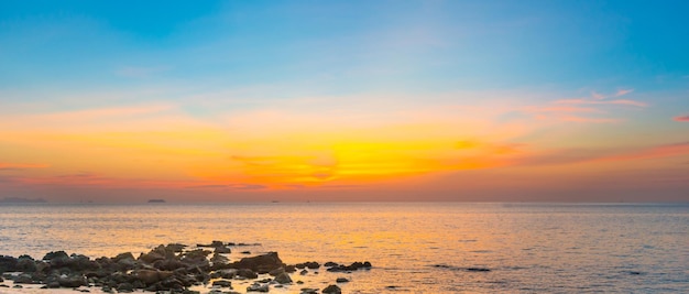 Plage au coucher du soleil avec mer et rochers