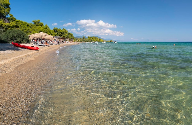 Plage avec bar de plage et touristes sur la mer Égée en Grèce