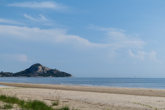 Plage calme avec un ciel bleu à la lumière du jour.