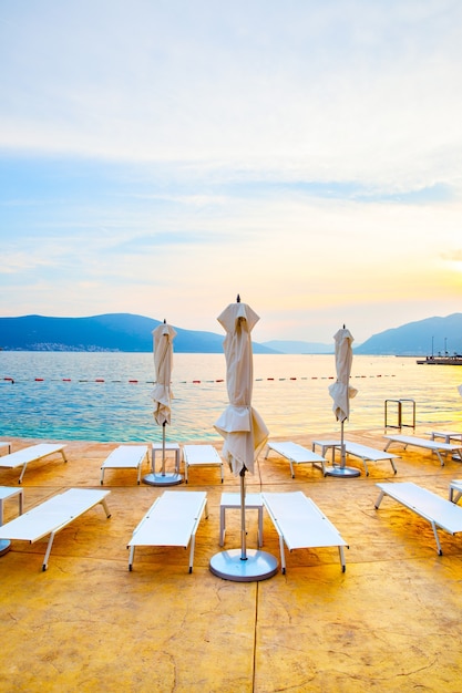 Plage avec chaises longues et parasols au coucher du soleil, Monténégro