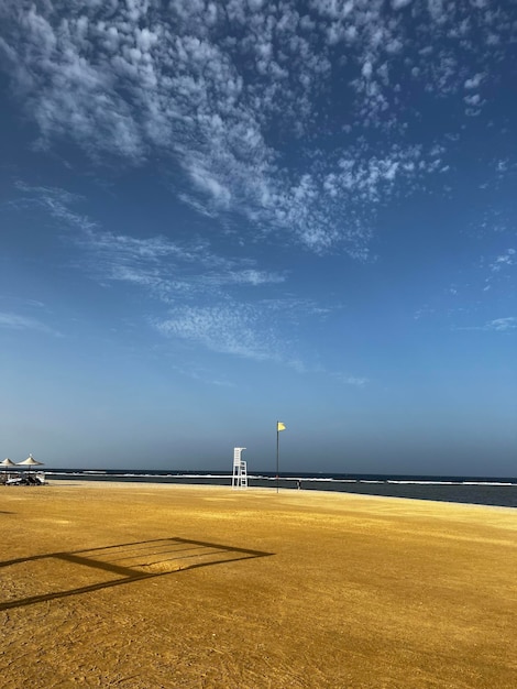 Une plage avec un ciel bleu et une dune de sable jaune.