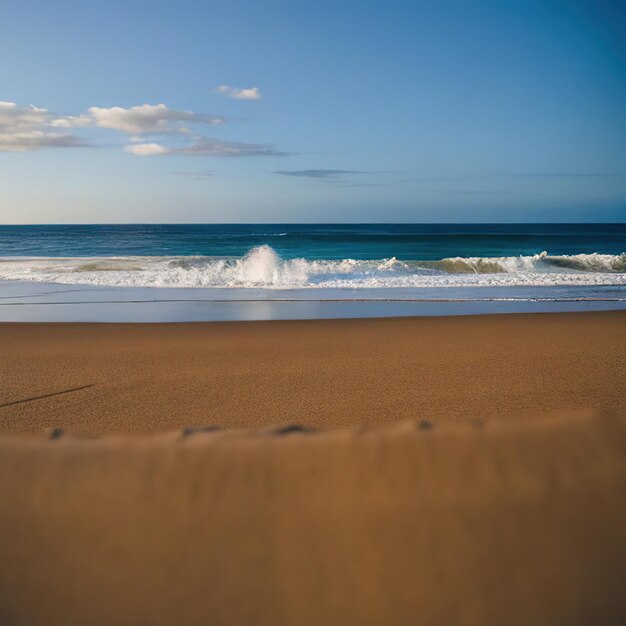 Une plage avec un ciel bleu et une vague qui s'écrase dessus