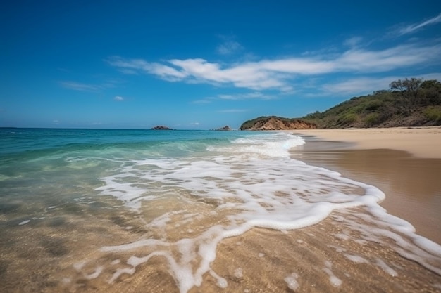 Une plage avec un ciel bleu et des vagues blanches se brisant sur le rivage.