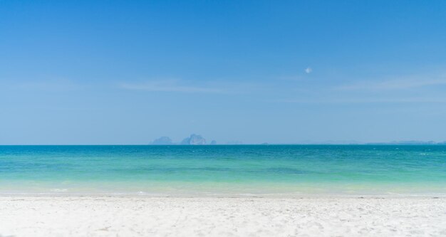 Plage claire avec fond de montagne et beau ciel bleu