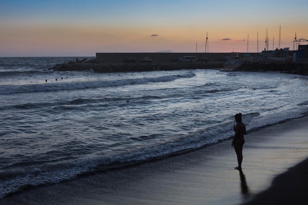 Une plage avec un coucher de soleil en arrière-plan