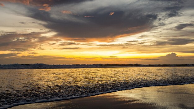 Une plage avec un coucher de soleil en arrière-plan