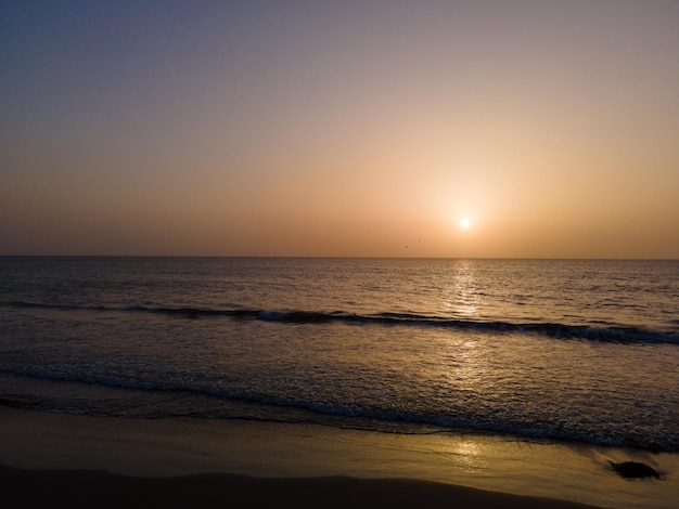 Photo une plage avec un coucher de soleil en arrière-plan