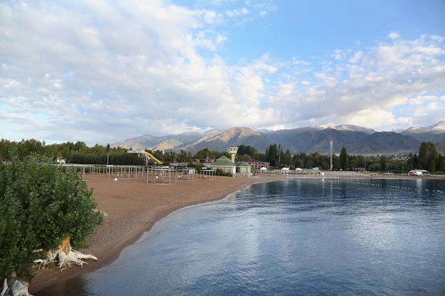 Photo plage du lac de montagne avec des nuages dans le ciel bleu