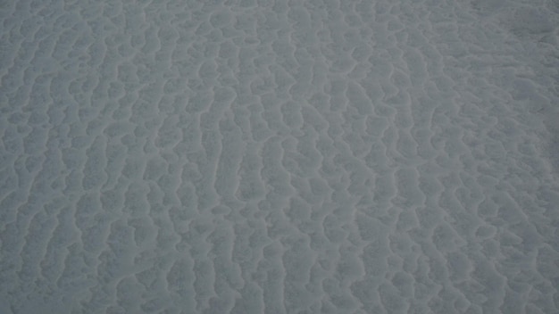 Photo une plage avec du sable blanc et des ondulations d'eau à la surface.