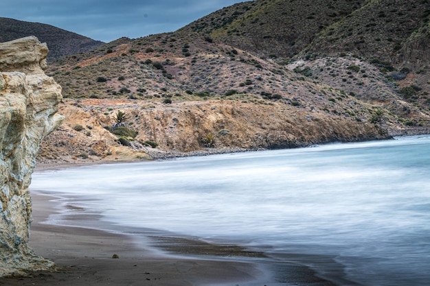 Plage d'Espagne au lever du soleil avec de gros rochers dans le sable