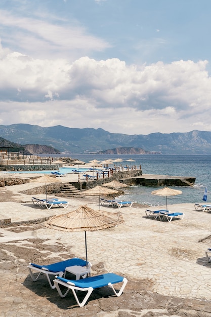 Plage de galets avec chaises longues et parasols