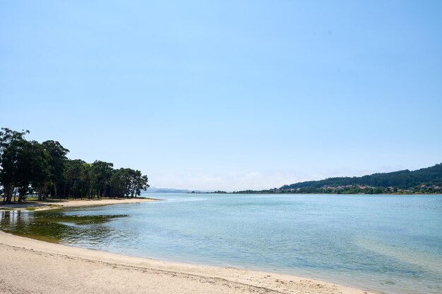 Plage galicienne avec rochers et ciel bleu. Fond naturel.