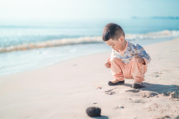 Sur la plage, un garçon joue dans le sable