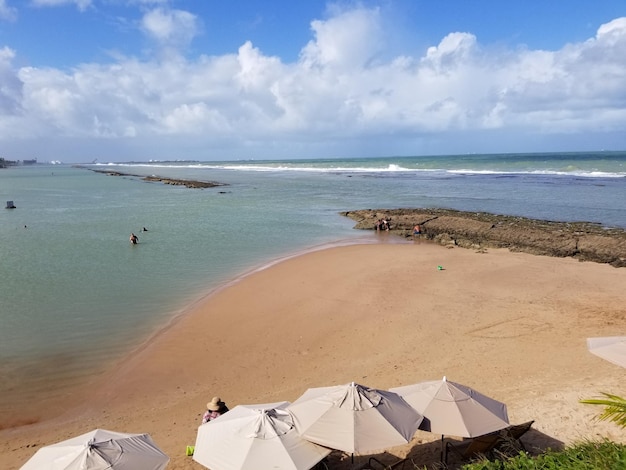 Photo une plage avec des gens dans l'eau et des parasols