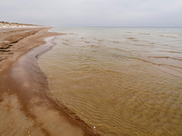 Plage d'hiver sur l'isthme de Courlande par temps nuageux en Lituanie