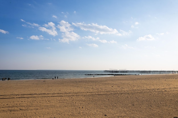 Une plage avec une jetée en arrière-plan