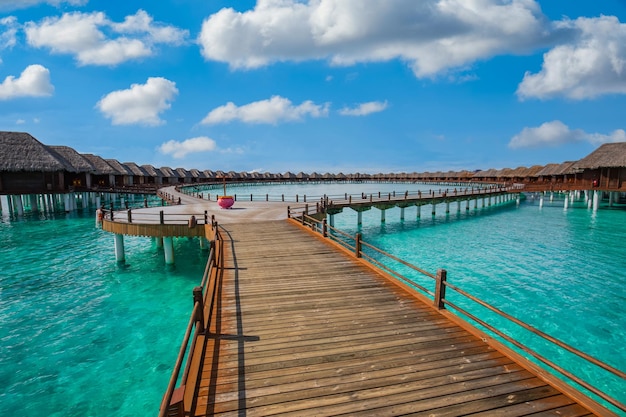 Plage des Maldives. Panorama tropical, complexe de villas de luxe sur l'eau avec jetée en bois. Fond de voyage