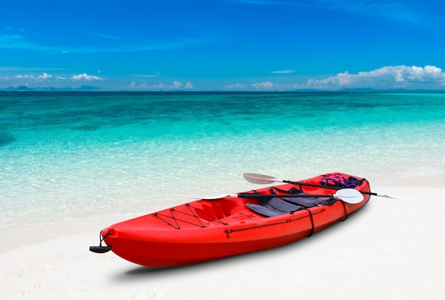 Plage de la mer bleue et bateau de kayak avec éclairage extérieur.