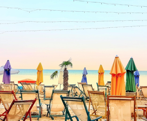 Plage de mer vide avec parasols et chaises fermés colorés pendant le verrouillage covid d'été