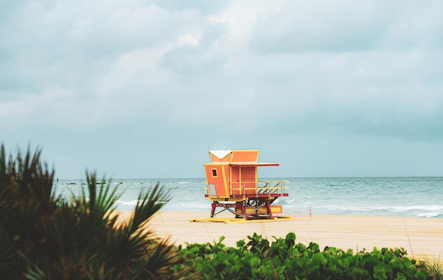 Plage de Miami avec tour de maître-nageur et littoral avec nuages colorés et océan de vacances de voyage de ciel bleu