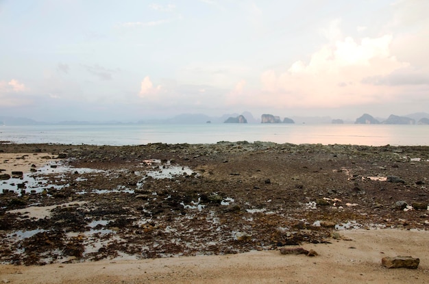 Plage de pierre avec l'heure du coucher du soleil à la mer d'Andaman à Ko Yao Noi à Phang Nga en Thaïlande